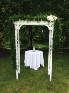 The arch with a hand-spun garland and cluster of white carnations, offset to infuse some personality 